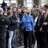 Hände und Handys: Als Kanzlerin Angela Merkel in Augsburg ankommt, nimmt sie sich ein bisschen Zeit, um die wartenenden Kuka-Mitarbeiter zu begrüßen.