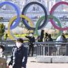 Zwei Japaner laufen mit Mundschutz an den Olympischen Ringen vorbei.