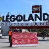 Heute ist das Legoland in Günzburg mit zwei Monaten Verspätung in die Sommersaison gestartet. Vor dem Eingang weist ein Schild die Besucher auf die Regeln hin. 	