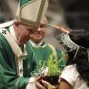 Ein Mädchen aus dem Amazonas-Gebiet überreicht Papst Franziskus während der Abschluss-Messe der Bischofssynode eine Pflanze.