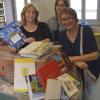 Die Gruppenleiterin der Bücherinsel, Elke Kaule und Mitarbeiterin Grazia Gallarotti. Die 140 Kartons Bücher hat Ulrike Wenger mit Unterstützung ihrer Selbsthilfegruppe Transmitter zusammengestellt (von links).  	