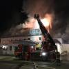 Feuerwehrleute löschen in der Nacht einen Brand in einem Wohnhaus. Aus bisher unbekannten Gründen brannte der Dachstuhl des Hauses. 