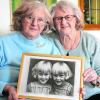 Anna Holzheu (links) und Gertraud Abröll sind eineiige Zwillinge und leben seit 20 Jahren gemeinsam im selben Haus. Aus ihrem Heimatort Erkheim sind sie nicht wegzudenken. Die Unterallgäuerinnen halten ein Foto in Händen, auf dem die beiden als Kinder zu sehen sind.  	