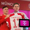 Der Sportdirektor des FC Bayern München, Christoph Freund (r), stellt bei einer Pressekonferenz den spanischen Fußballspieler Bryan Zaragoza vor und übergibt ihm das Trikot mit der Nummer 17.