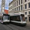 Zwei Trambahnen fahren vor dem Rathausplatz in Augsburg.