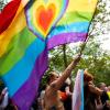 Ein Teilnehmer der «CSD Berlin Pride» trägt eine Regenbogenfarbene Flagge mit einem Herz. (Symbolbild).