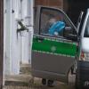 Ein Polizist trägt am Dienstag in Wiesent (Oberpfalz) eine Tüte mit Beweismaterial aus einem Anwesen. 