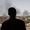 Ein Mann blickt auf die Stadt Khartum, wo schwarzer Rauch aufsteigt. Im Zuge der anhaltenden Kämpfe im Sudan ist die Zahl der Flüchtlinge massiv angestiegen.  