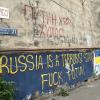 An einer Hauswand in einem Viertel der Hauptstadt Tiflis stehen auf Englisch und auf Ukrainisch antirussische Parolen, die den Krieg von Kremlchef Wladimir Putin gegen die Ukraine verurteilen.