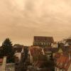 Über Augsburg hat sich der Himmel braun-rötlich gefärbt. Grund dafür ist Saharastaub.