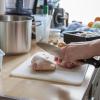 Ein eigenes Schneidebrett für Hähnchenkeulen: Fleisch sowie Obst oder Gemüse sollten Verbraucher in der Küche streng trennen.