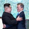 Kim Jong Un (links) und Moon Jae In umarmen sich.