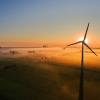 Die aufgehende Sonne taucht über Feldern und Windrädern den Nebel in warmes Licht. Im ersten Halbjahr ist der Ausbau der Windkraft an Land fast zum Erliegen gekommen.