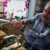 Hier demonstriert der 80-jährige Michael Stürzenhofecker, wie er mit ruhiger Hand und selbst gebauten Greifwerkzeug eine der millimeterkleinen Krippenfiguren über die schmale Flaschenhalsöffnung einführt.