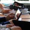 Schülerinnen und Schüler sitzen mit Tablets im Klassenzimmer.