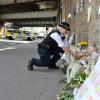 Eine Polizistin legt Blumen in der Nähe der Moschee in  Finsbury Park nieder.