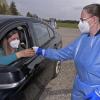Eine Frau im Auto gibt den Probenbecher beim freiwilligen Corona-Schnelltest im Drive-In einer Mitarbeiterin, zur Untersuchung auf Corona-Viren. Es ist ein sogenannter Spuck-Test, der im Testzentrum Bad Wlrishofen zum Einsatz kommt. 