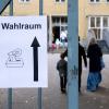 Ein Schild mit der Aufschrift «Wahlraum» hängt an einem Tor vor einem Wahllokal im Stadtteil München-Neuhausen.