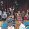 Ganz junge und altgediente Musiker auf und vor der Bühne in der Turnhalle in Osterberg unterhalten die Gäste mit festlicher Musik zu Weihnachtszeit und Jahreswechsel. Im Hintergrund Kinder der musikalischen Früherziehung mit Orffinstrumenten.  