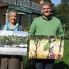 Stefanie Windhausen-Grellmann und Alexander Hermann mit Fotos der Kolumbien-Reise, die in einer Ausstellung gezeigt werden. 	