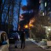 Anwohner beobachten ein brennendes Gebäude in Kiew, das bei einem Drohnenangriff getroffen wurde.