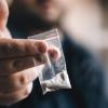 Drug dealer offers cocaine dose or another drugs in plastic bag, drug addiction on party concept, selective focus, toned
Kokain