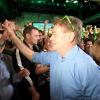 Werner Kogler, Parteichef der Grünen, wird bei einer Wahlparty von Anhängern bejubelt: Er hat die Partei zurück ins Parlament geführt.