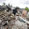 Ein Mann geht über die Trümmer eines vom Erdbeben zerstörten Hauses.Foto: Firdia Lisnawati/AP