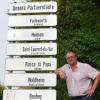 Stadtrat Harry Reitmeir (CSU) am Schild für die Partnerstädte der Stadt Landsberg.