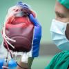 Eine Ärztin hält am einen Beutel mit Erythrozytenkonzentrat in einem Operationssaal. 