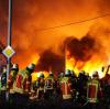 Feuerwehrleute stehen am Einsatzort bei der Firma Burgmaier in Allmendingen.