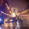 Polizisten stehen an einem Kontrollpunkt auf der Champs-Élysées in Paris. In Frankreich gilt wegen der Corona-Krise seit dem 16. Januar eine nächtliche Ausgangssperre von 18 Uhr an.