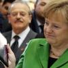 Bundeskanzlerin Angela Merkel betrachtet auf der Computermesse CeBIT in Hannover einen wasserfesten Tablett-PC. Foto: Daniel Reinhardt dpa
