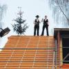 Zwei aktive Mitglieder der Freiwilligen Feuerwehr Tiefenbach, Vereinsvorsitzender Andreas Kraus (rechts) und Christian Geist (links), brachten neben dem festlich geschmückten Bäumchen auf dem Dachfirst den Richtspruch zum Um- und Anbau des Gerätehauses aus.  
