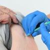 Eine Seniorin bekommt in einem Impfzentrum ihre Impfung gegen Covid-19 verabreicht.