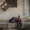 Syrische Kinder sitzen zwischen beschädigten Gebäuden im Dorf Afes. Rund zehn Jahre nach dem Beginn des Syrien-Konfliktes beklagt der UN-Menschenrechtsrat schwere Kriegsverbrechen in dem Krisenland.