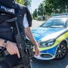 Ein Polizist steht mit seiner Waffe in Esslingen auf einem Zufahrtsweg zur Friedrich-Ebert Schule.