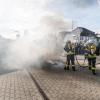 Einsatzkräfte löschen ein Feuer, das Demonstranten beim politischen Aschermittwoch der baden-württembergischen Grünen vor der Stadthalle von Biberach an der Riß angezündet haben.