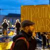 Dieser Demonstrant auf dem Rathausplatz trägt am Freitagabend ein Schild mit der Leuchtschrift "Stop Putin, Stop War". 