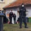 Polizisten stehen vor einem Hintereingang eines Gebäudes in Eisenach (Thüringen), das sie durchsuchen. Ermittler gingen am Mittwochmorgen gegen mutmaßliche Rechtsextremisten vor. 
