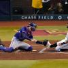 Christian Walker (r) von den Arizona Diamondbacks wird während des zweiten Innings von Jonah Heim, dem Catcher der Texas Rangers, an der Home Plate abgefangen.