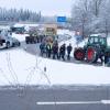 Zu Beginn der Protestwoche startet ein Traktoren -und LKW-Konvoi nach München. Etliche Landwirte und Spediteure blockieren mit ihren Fahrzeugen die beiden Kreisverkehre an der A96.