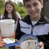 Stolz zeigt Maximilian einige Kleinlebewesen, welche die Schüler an diesem Vormittag aus dem Wasser herausgefischt haben. 