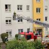 Eine Frau spricht in Königsbrunn mit einem Feuerwehrmann auf der Drehleiter. Drei Wohnungen mussten Einsatzkräfte öffnen, nachdem ein Longboard einen Brand ausgelöst hatte.