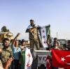 Syrische Oppositionskämpfer, die von der Türkei unterstützt werden, jubeln in Akcakale (Türkei), nachdem sie von Tall Abyad (Syrien) über die Grenze gekommen sind. 