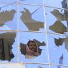 Geschundenes Afghanistan: Ein Mann sieht durch eine zerbrochenen Fensterscheibe nach einem Raketenangriff.  