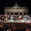 Vor 30 Jahren: Jubelnde Menschen auf der Berliner Mauer am Brandenburger Tor.