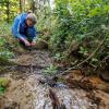 Eva Schubert, Landschafts- und Gewässerökologin vom LBV - Landesbund für Vogel- und Naturschutz in Bayern e.V., begutachtet einen renaturierten Bach.