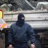 Ein maskierter Serbe sieht zu, wie Lastwagen von einer Barrikade entfernt werden. Der Abbau der Sperren nährt die Hoffnung auf ein Ende der Eskalationsspirale im Kosovo. 