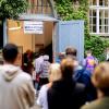 Wählerinnen und Wähler warten im Stadtteil Prenzlauer Berg in einer langen Schlange vor einem Wahllokal.